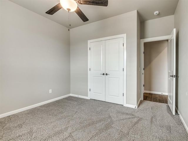 unfurnished bedroom with a closet, carpet flooring, a ceiling fan, and baseboards