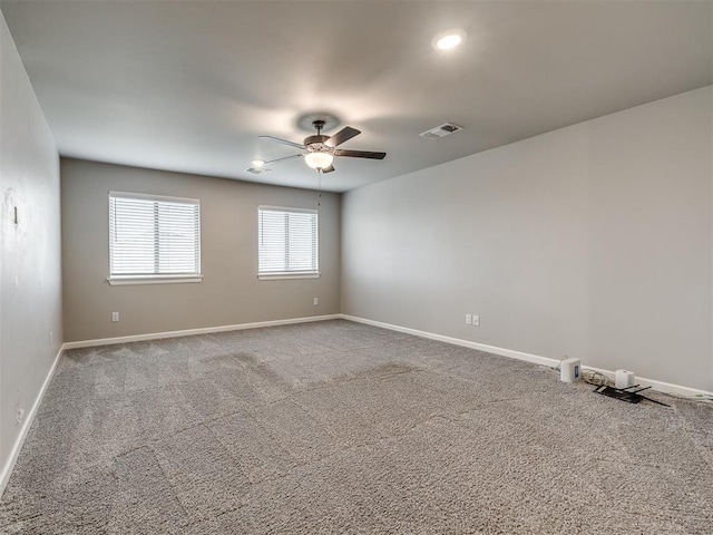 spare room with visible vents, baseboards, carpet, and a ceiling fan