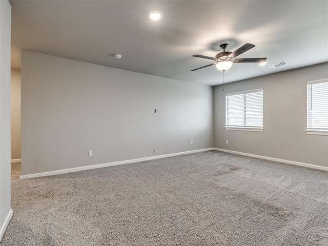 spare room featuring visible vents, carpet flooring, a ceiling fan, and baseboards