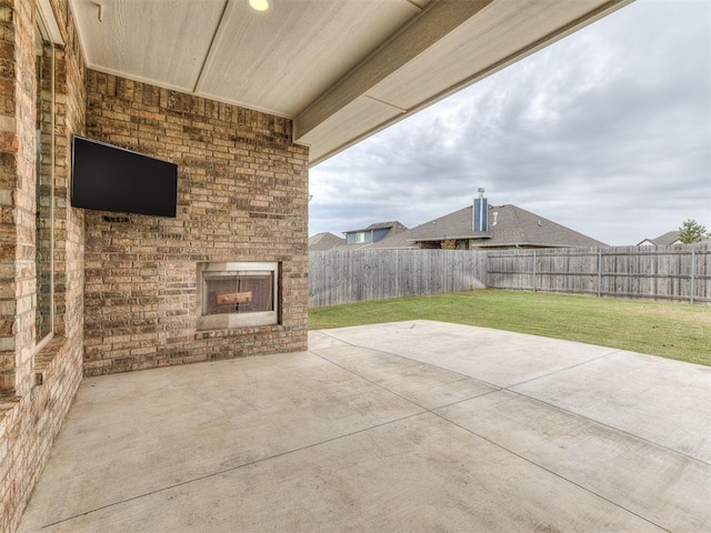 view of patio with a fenced backyard and an outdoor brick fireplace