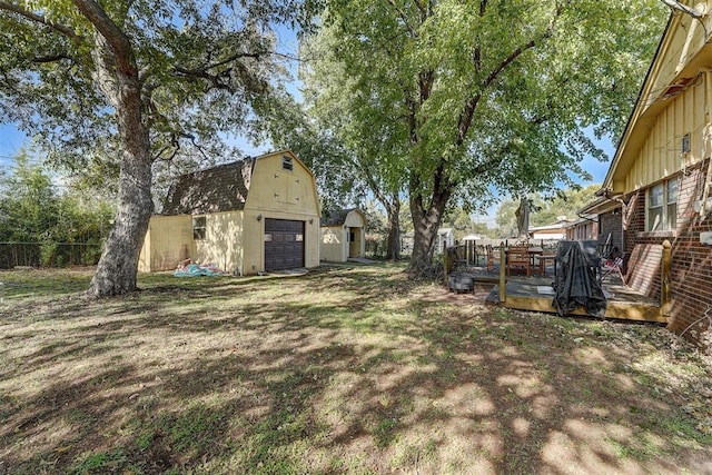 view of yard featuring an outbuilding, a garage, and a wooden deck