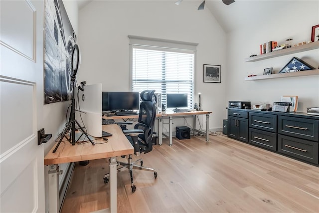 home office with ceiling fan, light hardwood / wood-style floors, and vaulted ceiling