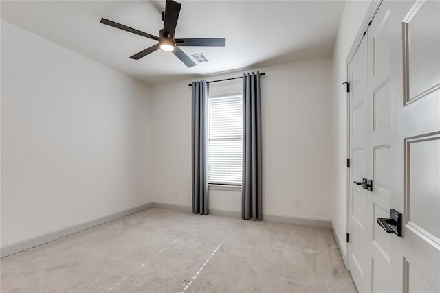 carpeted spare room with ceiling fan