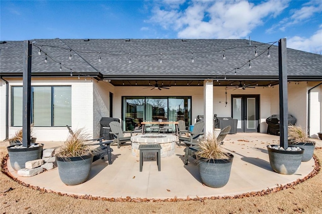 back of property with a fire pit, ceiling fan, and a patio