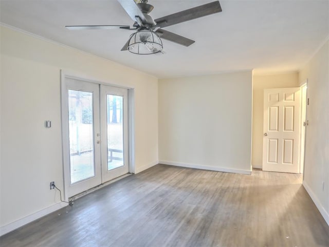 empty room with french doors, ceiling fan, and hardwood / wood-style floors