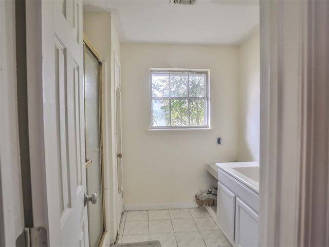 bathroom featuring tile patterned flooring, vanity, and a shower with shower door