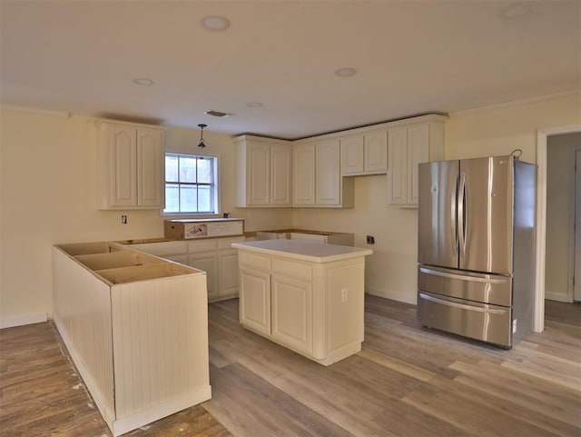 kitchen with a center island, stainless steel fridge, and light hardwood / wood-style floors