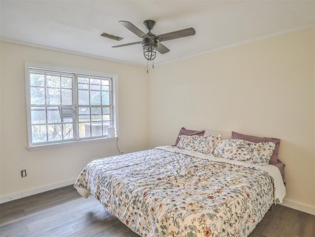 bedroom with ceiling fan, dark hardwood / wood-style flooring, and crown molding