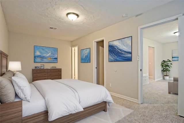 bedroom featuring light carpet and a textured ceiling