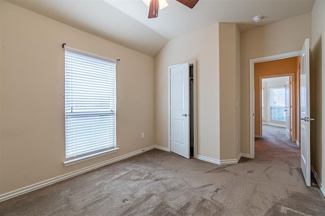 unfurnished bedroom featuring ceiling fan, light colored carpet, and vaulted ceiling