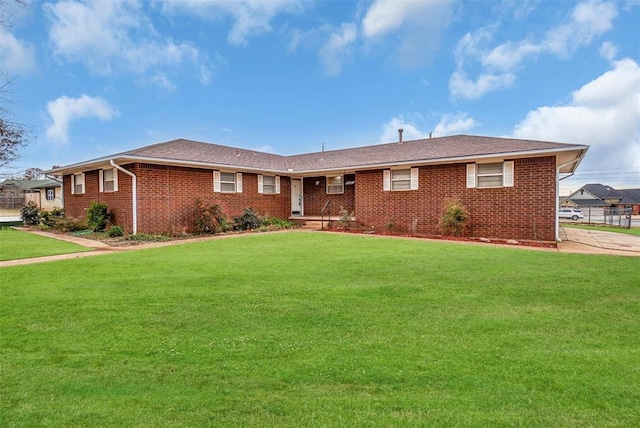 ranch-style house featuring a front yard and brick siding