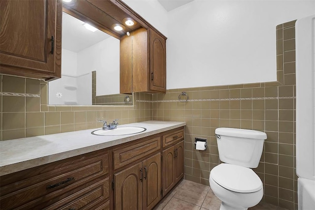 bathroom with tile patterned floors, vanity, toilet, and tile walls