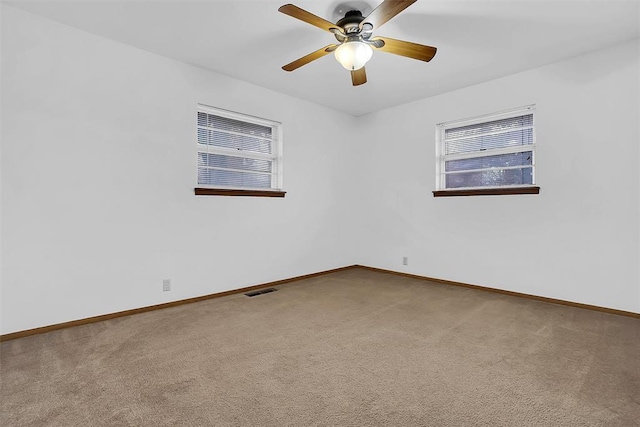 carpeted spare room with ceiling fan