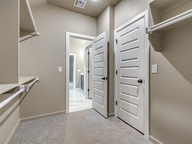 spacious closet featuring light colored carpet