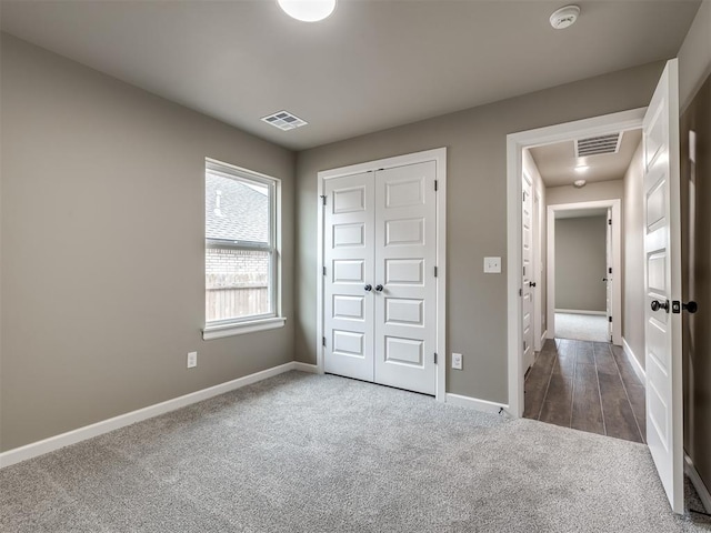 unfurnished bedroom featuring a closet and dark colored carpet