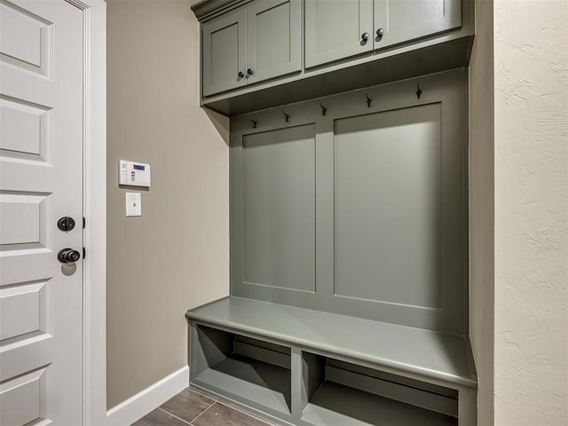 mudroom with dark tile patterned floors