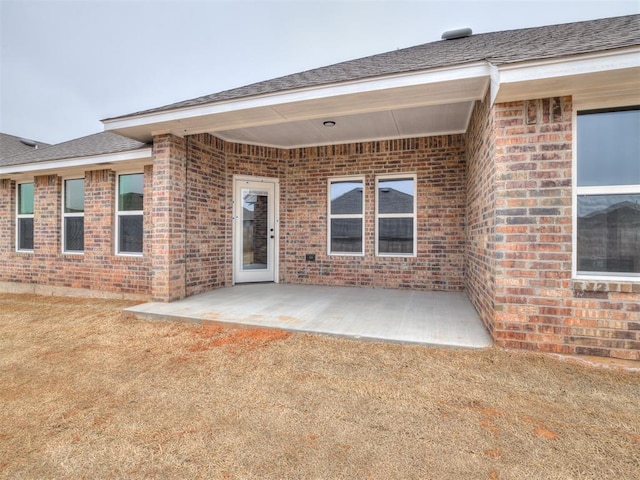 entrance to property featuring a patio and a yard