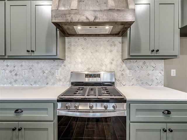 kitchen featuring decorative backsplash, stainless steel range with gas stovetop, and custom exhaust hood