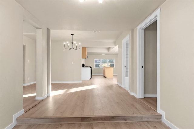 corridor featuring a chandelier and light hardwood / wood-style flooring