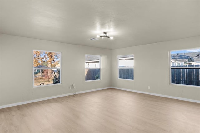 unfurnished room featuring a wealth of natural light and light hardwood / wood-style flooring