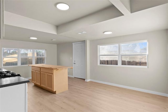 kitchen featuring a center island, stove, light wood-type flooring, and light brown cabinets