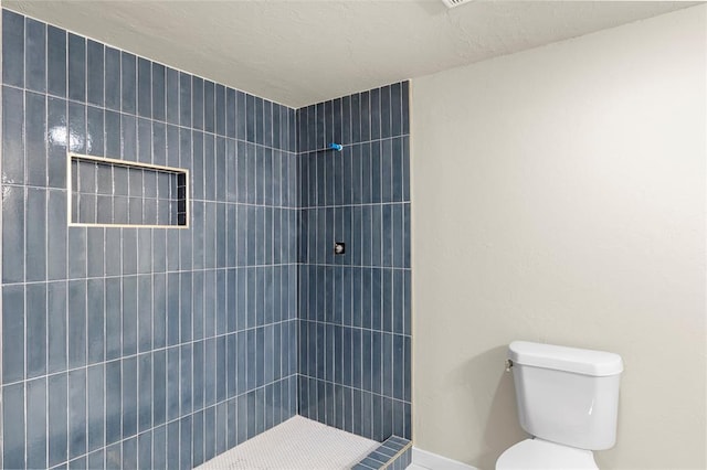 bathroom featuring toilet and tiled shower