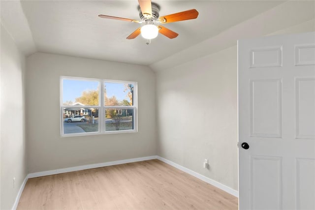 empty room featuring ceiling fan, light hardwood / wood-style floors, and vaulted ceiling