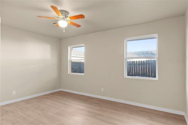 spare room with ceiling fan, light hardwood / wood-style flooring, and a healthy amount of sunlight