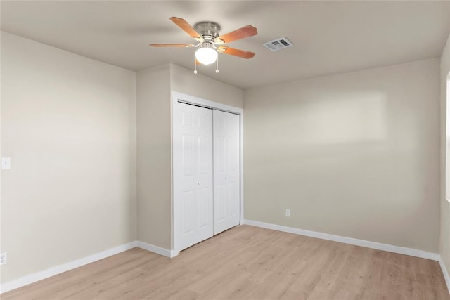 unfurnished bedroom with ceiling fan, a closet, and light hardwood / wood-style floors