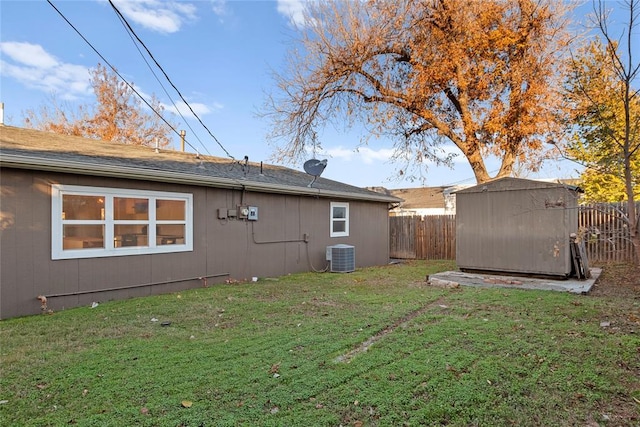 back of property featuring a yard, cooling unit, and a storage shed