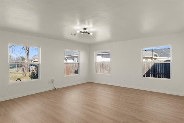 unfurnished room with visible vents, baseboards, and light wood-style flooring