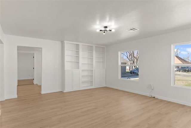 empty room with visible vents, baseboards, and light wood-style floors