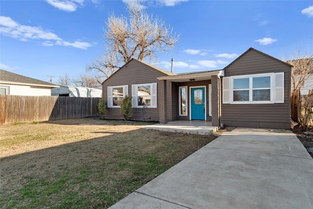 single story home featuring a front lawn and fence