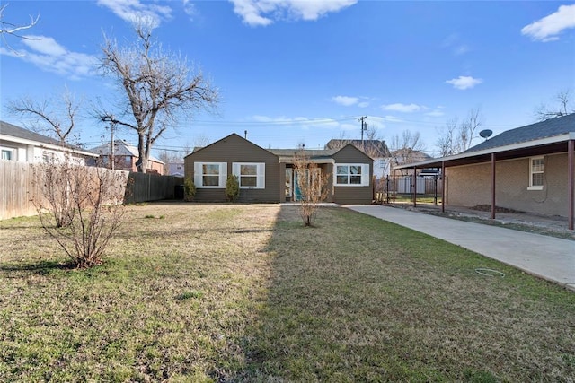 ranch-style home with a front lawn, concrete driveway, and fence