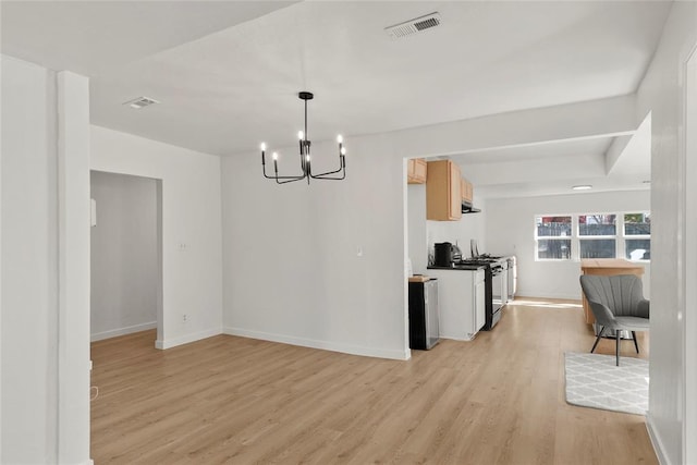 dining space featuring a notable chandelier, baseboards, visible vents, and light wood finished floors