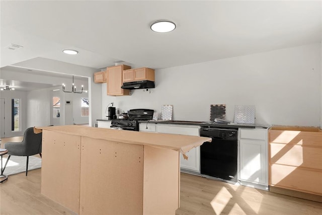 kitchen featuring black appliances, light wood-style flooring, under cabinet range hood, and a center island