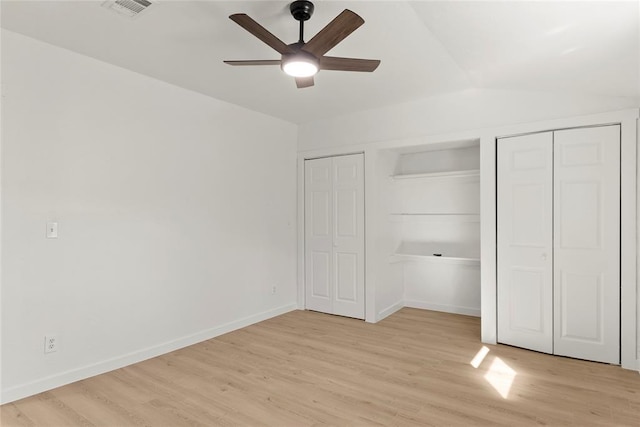 unfurnished bedroom featuring visible vents, ceiling fan, baseboards, multiple closets, and light wood-type flooring