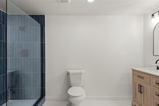 full bath with toilet, marble finish floor, a tile shower, baseboards, and vanity