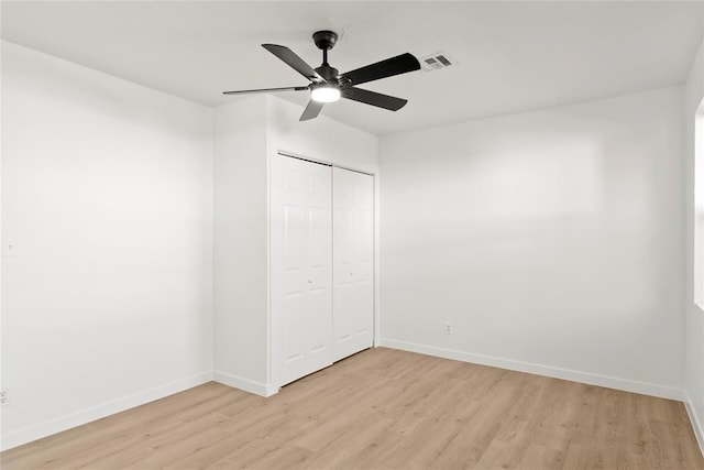 unfurnished bedroom with a closet, visible vents, baseboards, and light wood finished floors