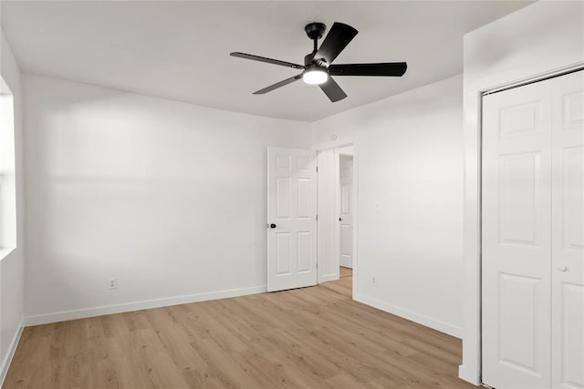 unfurnished bedroom with ceiling fan, a closet, baseboards, and light wood-style flooring