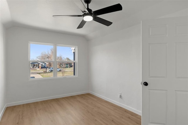 unfurnished room with ceiling fan, baseboards, light wood-style floors, and vaulted ceiling