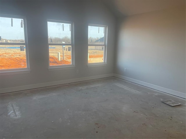 unfurnished room with lofted ceiling and concrete flooring