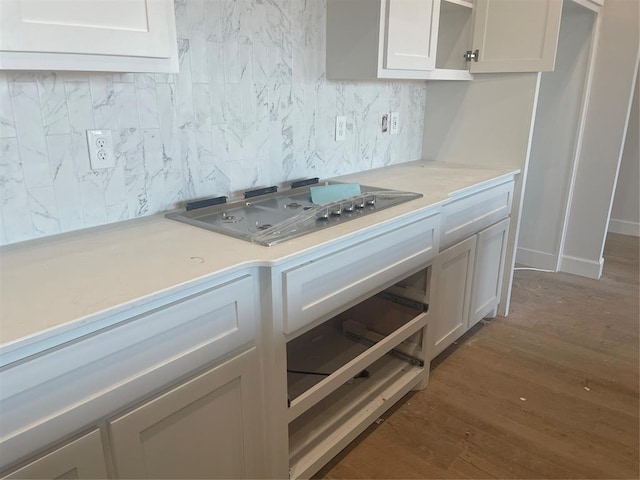 kitchen with white cabinetry, backsplash, dark hardwood / wood-style flooring, and stainless steel gas stovetop