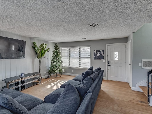 living room with a textured ceiling and light hardwood / wood-style flooring