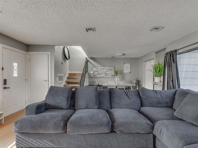 living room featuring wood-type flooring and a textured ceiling