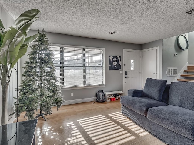 living room featuring light hardwood / wood-style floors and a textured ceiling