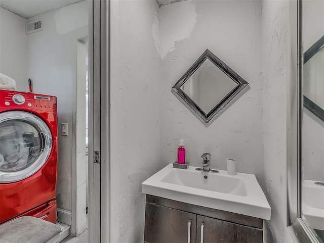 bathroom with vanity and washer / clothes dryer