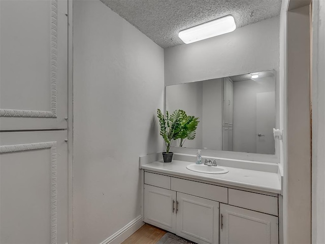 bathroom featuring hardwood / wood-style floors, vanity, and a textured ceiling