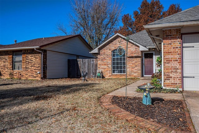 back of property featuring a lawn and a garage