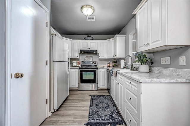 kitchen featuring white cabinetry, sink, stainless steel appliances, and light wood-type flooring